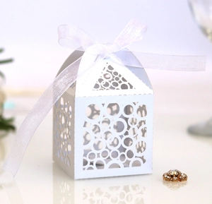 Detail of laser cut circular patterns on white paper gift box with a white ribbon bow