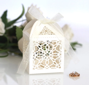 Elegant white laser-cut candy box with starburst pattern and ribbon bow for weddings