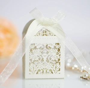 Detail of laser-cut wedding gift box with floral patterns and a cream silk ribbon bow