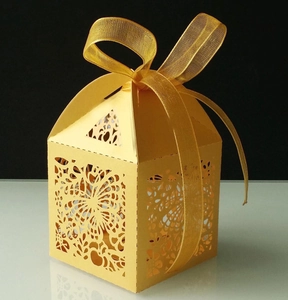 Detail of yellow laser-cut gift box featuring hollow butterfly patterns and satin ribbon bow