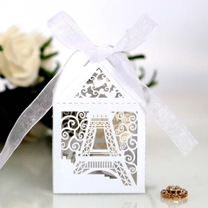 Detail of laser-cut Eiffel Tower white candy box with ribbon for wedding party favors