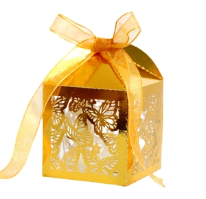 Macro detail of laser-cut butterfly wedding candy box in golden metallic finish