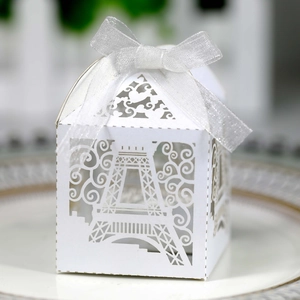 Detail of laser-cut white paper gift box with Eiffel Tower pattern and organza ribbon