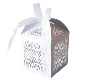 Detail showing white laser-cut hollow pattern and silk ribbon on the wedding favor box