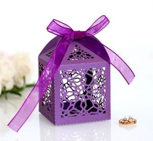 Detail view of purple laser-cut lace candy box with elegant star pattern and ribbon bow