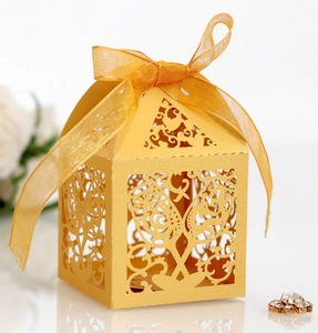 Golden laser-cut gift box featuring intricate vine patterns and a silk ribbon bow