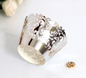 Detailed macro view of laser-cut silver cupcake wrappers with vintage baroque patterns