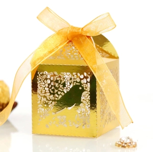 Gold laser-cut gift box with love bird patterns and a yellow silk ribbon bow on white background