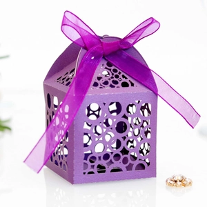 Macro shot of purple laser-cut candy box with geometric patterns and organza ribbon bow