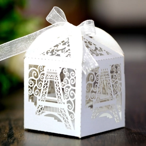 Detailed laser-cut Eiffel Tower pattern on a white candy box with ribbon