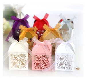 Detail of laser-cut butterfly favor boxes with elegant ribbons in multiple colors