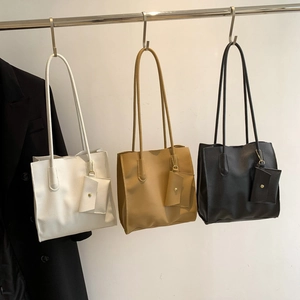 Three minimalist large-capacity tote bags in white, khaki, and black with small pouches