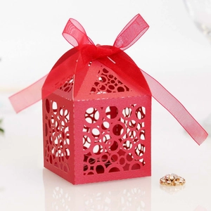 Red laser-cut gift box with intricate circular patterns and matching sheer ribbon bow