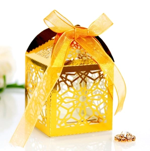 Elegant laser-cut hollow gold wedding favor box with a yellow ribbon and crystal accent