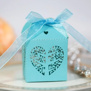 Detail of light blue laser-cut candy box with heart leaf pattern and organza bow