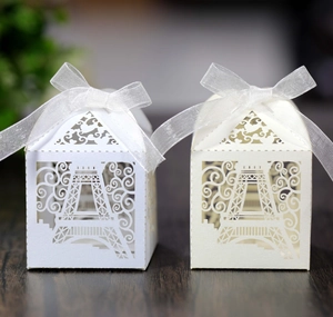 Laser cut Eiffel Tower favor boxes in white and beige with elegant ribbon bows