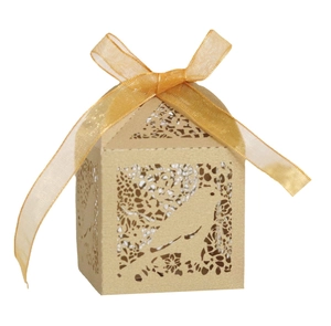 Detail of laser-cut floral and bird pattern on kraft paper wedding favor box with ribbon