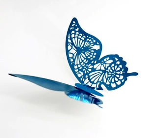 Dettaglio ravvicinato di farfalla 3D blu con intaglio traforato e finitura metallica