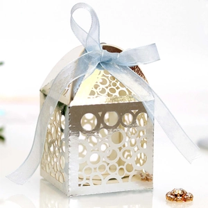 Detailed view of silver laser-cut candy box with blue ribbon bow and jewel accent