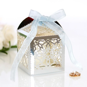 Close-up of silver laser-cut wedding favor box with a light blue satin ribbon bow