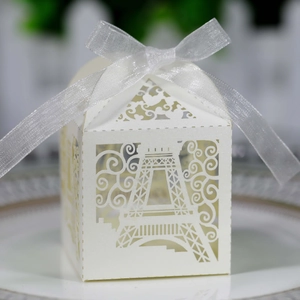 Detail of white laser-cut Eiffel Tower candy box with an elegant ribbon bow