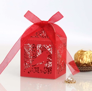 Detailed laser-cut red paper favor box with bird patterns and red organza ribbon
