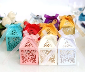 Hollow laser cut Chinese style candy boxes with elegant ribbons for wedding celebrations