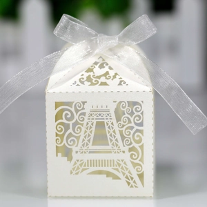 Detailed laser-cut Eiffel Tower pattern on white wedding favor box with silver ribbon