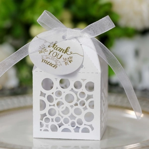 Detailed macro view of laser-cut gift box with white ribbon and golden Thank You tag