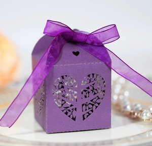 Detail of laser-cut purple gift box with heart pattern and elegant organza ribbon bow