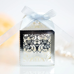 Detailed laser-cut silver wedding favor box with blue ribbon and elegant floral patterns