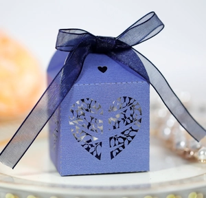Detail of purple laser-cut candy box with heart tree pattern and silk ribbon bow