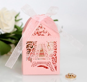 Close-up of pink laser-cut candy box with Eiffel Tower design and white ribbon bow