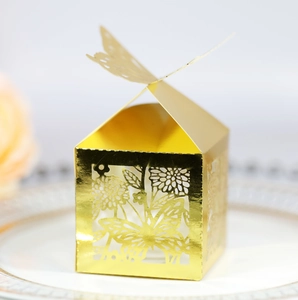 Détail d'une boîte dorée découpée au laser avec papillon et motifs floraux élégants