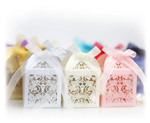 Detailed laser-cut floral pattern and silk ribbon on elegant pearlescent wedding favor boxes