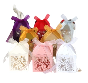 Laser-cut wedding favor boxes with butterfly patterns and ribbon bow decorations