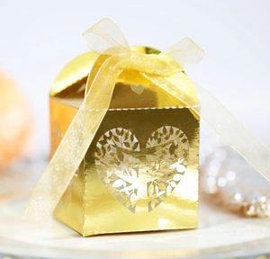 Close-up of laser-cut heart tree candy box with gold ribbon and metallic finish