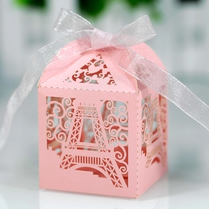 Macro detail of laser-cut Eiffel Tower pink favor box with silver ribbon and pearl finish