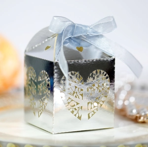 Macro shot of silver metallic candy box featuring laser-cut heart and light blue silk ribbon