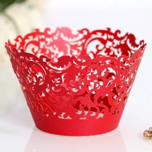 Red laser-cut lace cupcake wrappers with intricate floral vine patterns for weddings