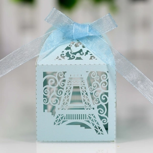 Macro detail of laser-cut Eiffel Tower pattern on light blue pearlescent gift box