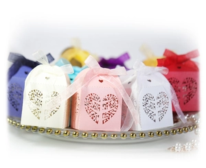Detail of laser-cut heart tree design on colorful candy boxes with silk ribbon bows