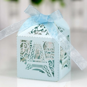 Detail of light blue laser-cut Eiffel Tower favor box with matching organza ribbon bow