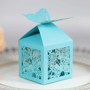 Détail macro des motifs floraux découpés au laser sur boîte cadeau bleu nacré