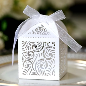 Macro view of white laser-cut hollow gift box with elegant ribbon and floral pattern