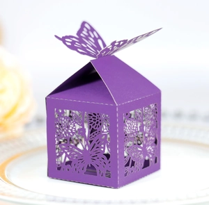 Boîte à bonbons papillon violet foncé découpée au laser sur une assiette pour mariages