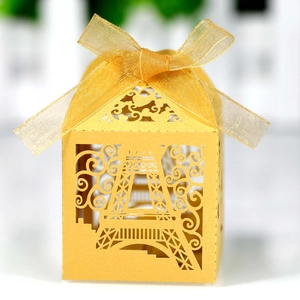 Detail of laser-cut Eiffel Tower candy box in gold pearlescent paper with ribbon