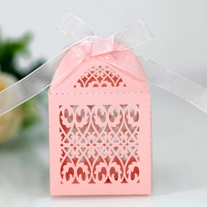 Detailed macro shot of pink laser-cut hollow gift box with elegant white organza ribbon