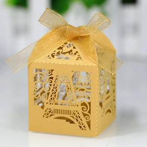 Detail of laser-cut Eiffel Tower candy box in gold glitter paper with silk ribbon bow