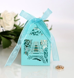 Detail of teal laser-cut Eiffel Tower candy box with silk ribbon bow for weddings